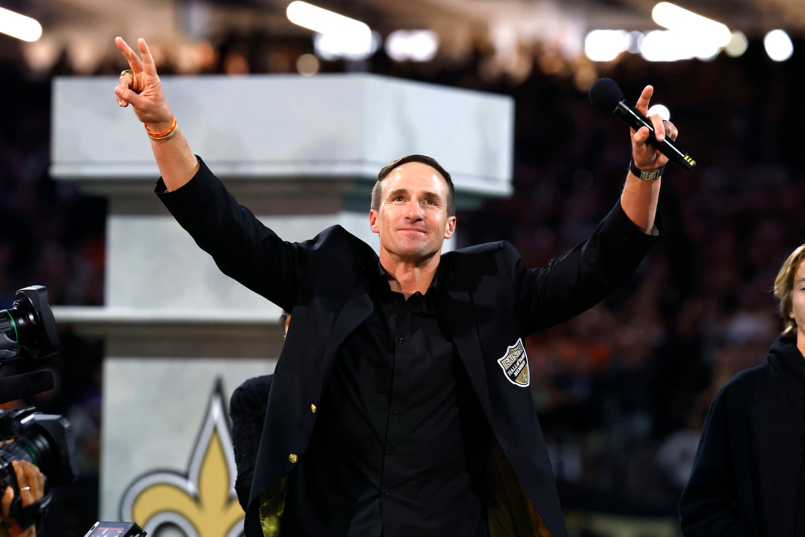 Former New Orleans Saints quarterback Drew Brees celebrates his induction in the Saints Hall of Fame during halftime of NFL football game between the Saints and the Denver Broncos, Thursday, Oct. 17, 2024, in New Orleans. (AP Photo/Butch Dill)