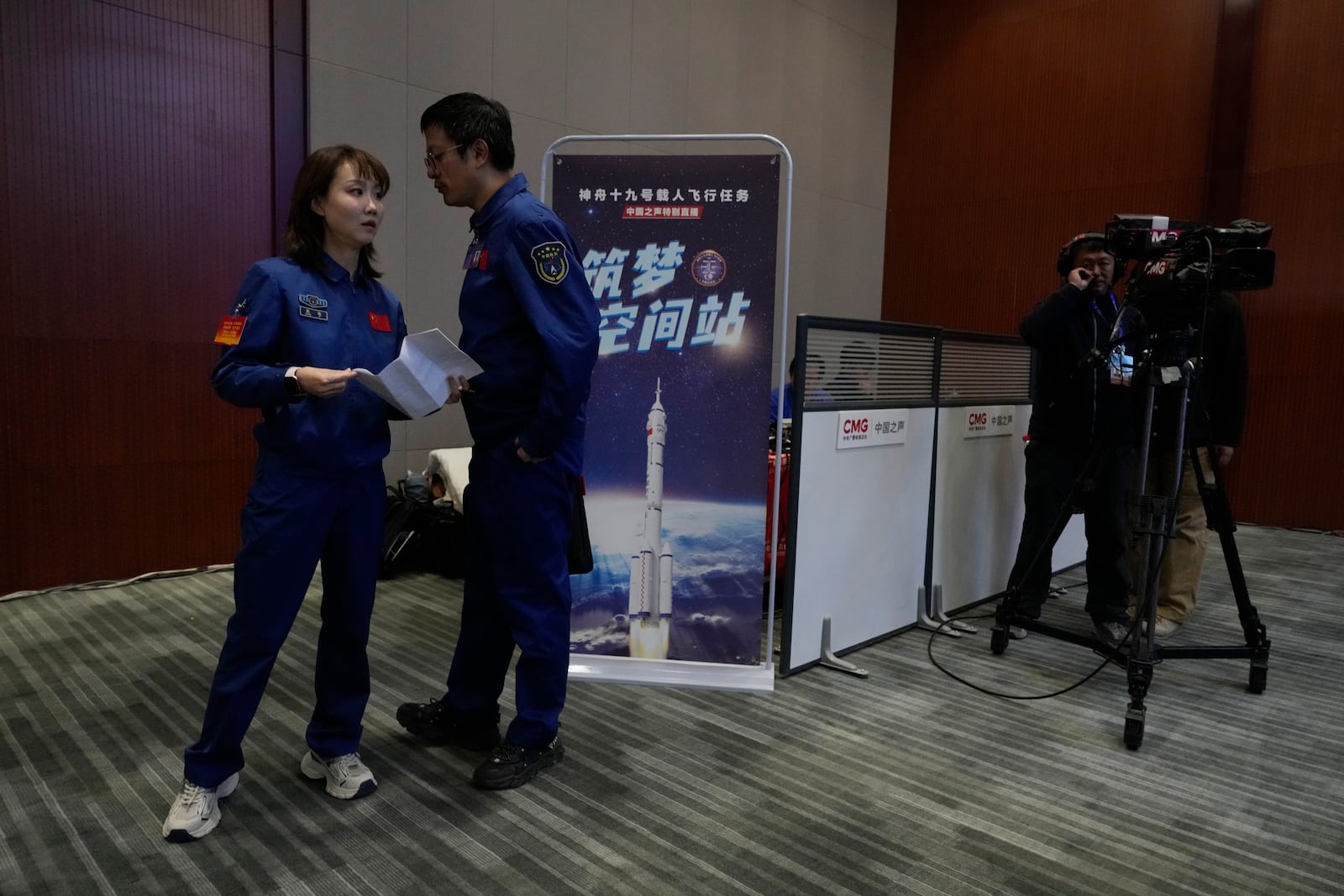 Staff prepare for a press conference ahead of the Shenzhou-19 mission at the Jiuquan Satellite Launch Center in Jiuquan, northwest China Tuesday, Oct. 29, 2024. (AP Photo/Ng Han Guan)