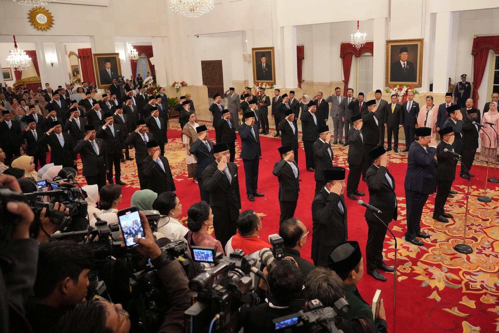 Indonesia's newly appointed cabinet ministers salute during their swearing-in ceremony at the presidential palace in Jakarta, Indonesia, Monday, Oct. 21, 2024. (AP Photo/Achmad Ibrahim)