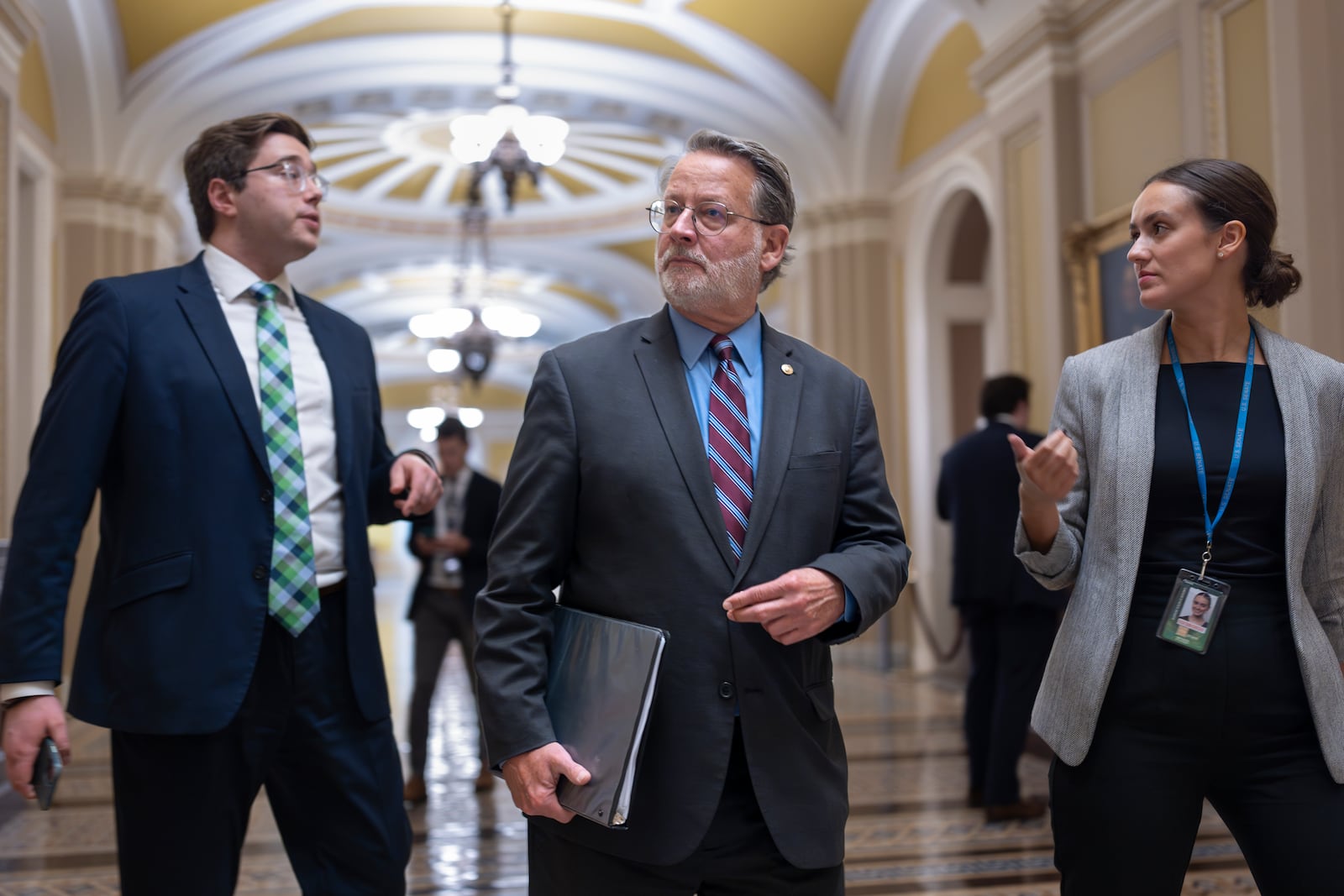 Sen. Gary Peters, D-Mich., left, chairman of the Senate Homeland Security and Governmental Affairs Committee, walks at the Capitol in Washington, Wednesday, Sept. 25, 2024. (AP Photo/J. Scott Applewhite)