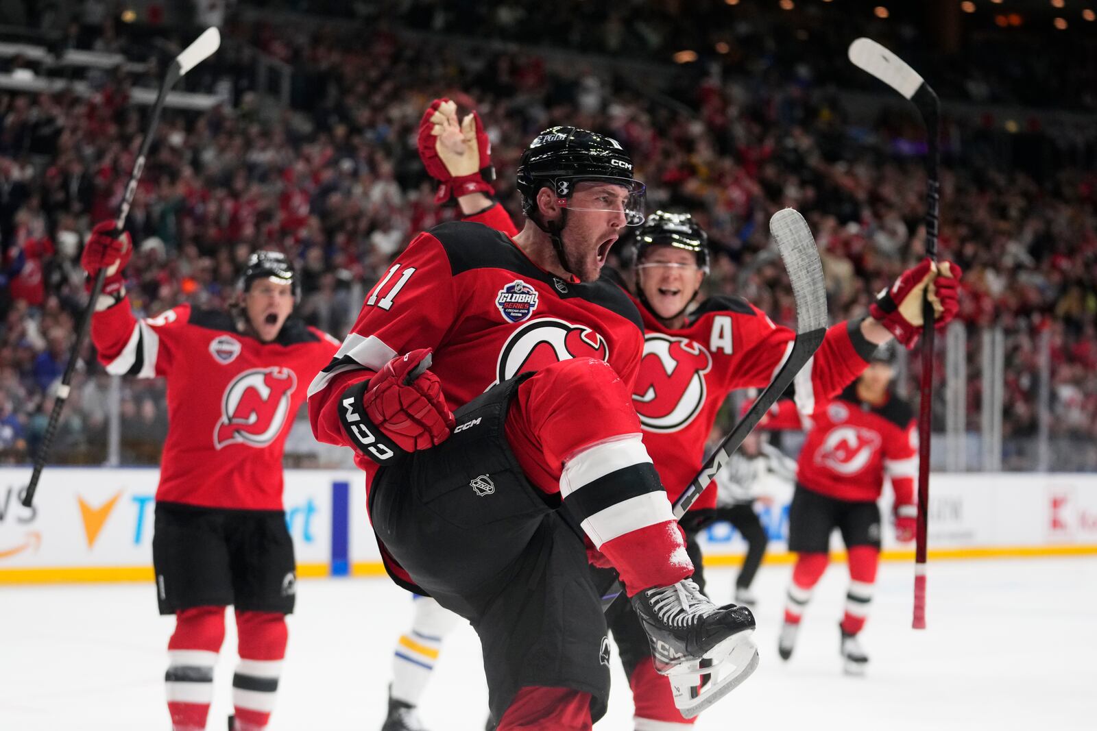 New Jersey Devils' Stefan Noesen, centre, celebrates after scoring the opening goal during the NHL hockey game between Buffalo Sabres and New Jersey Devils, in Prague, Czech Republic, Friday, Oct. 4, 2024. (AP Photo/Petr David Josek)