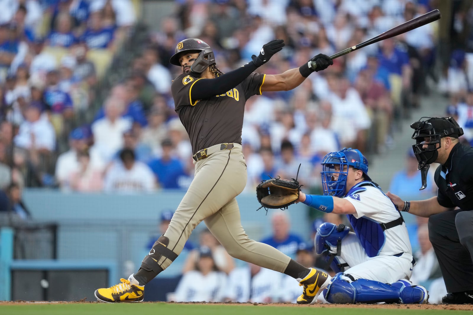 San Diego Padres' Fernando Tatis Jr. watches his double in front of Los Angeles Dodgers catcher Will Smith, bottom, during the third inning in Game 2 of a baseball NL Division Series, Sunday, Oct. 6, 2024, in Los Angeles. (AP Photo/Ashley Landis)