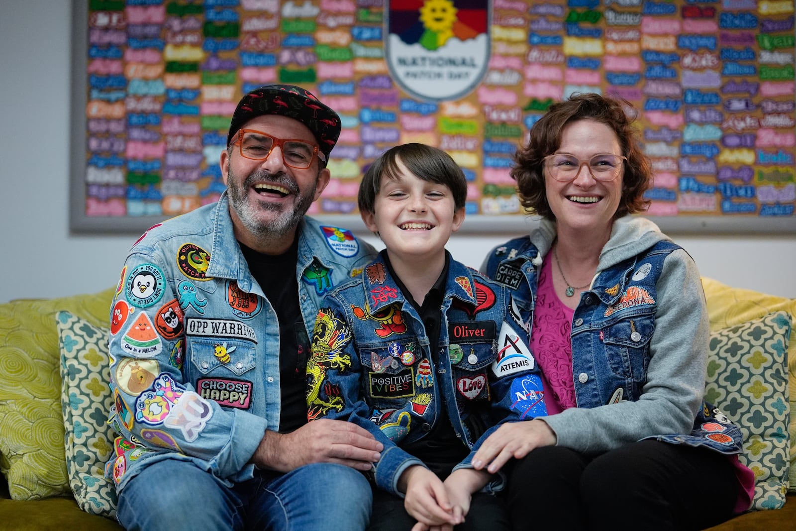 Brian Burkhardt, left, and Trisha Brookbank, right, pose for a picture with their son Oliver Burkhardt, 13, in the offices of the Oliver Patch Project, Wednesday, Sept. 4, 2024, in Miami. (AP Photo/Rebecca Blackwell)