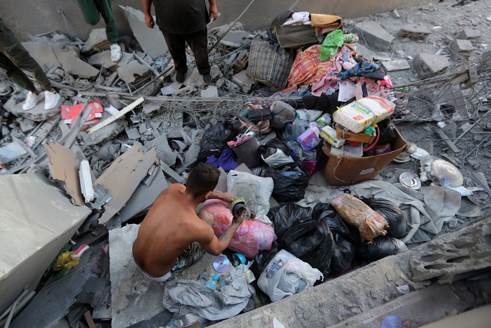 A Lebanese man collects belongings from his destroyed apartment that was hit by an Israeli airstrike, in Tyre, south Lebanon, Thursday, Oct. 24, 2024. (AP Photo/Mohammed Zaatari)