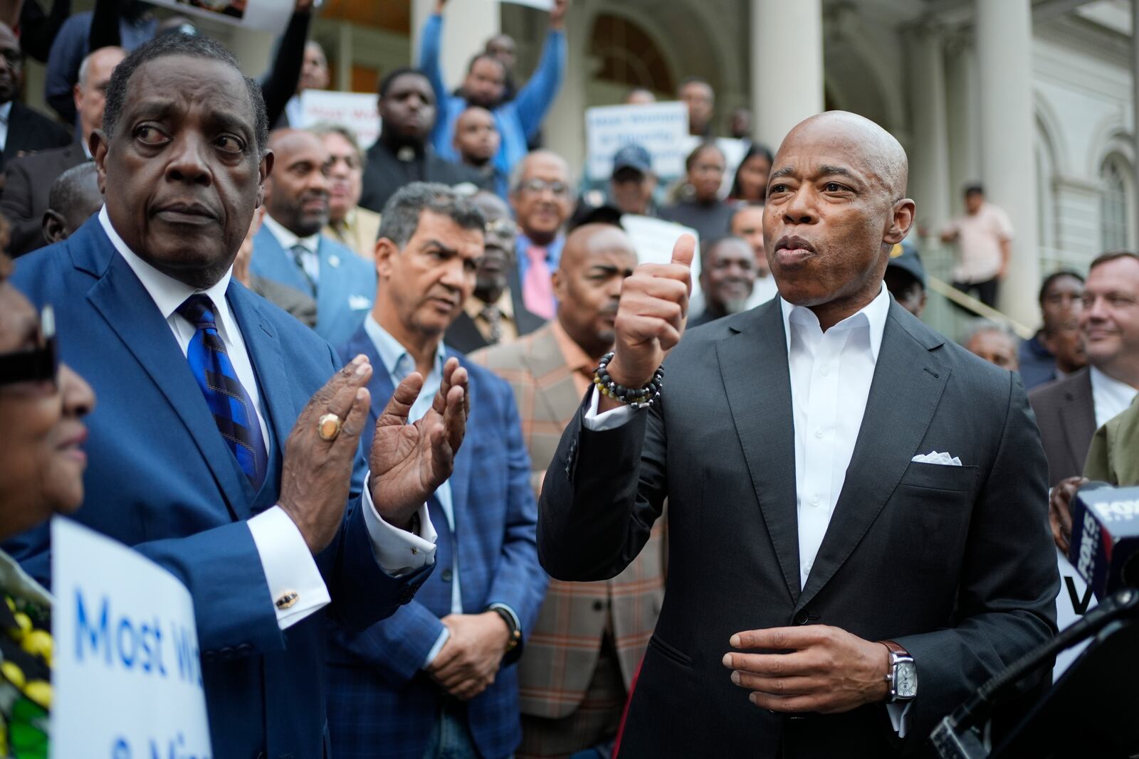 New York City Mayor Eric Adams, right, is surrounded by faith leaders and other supporters during a rally and prayer vigil on the steps of City Hall in New York, Tuesday, Oct. 1, 2024. (AP Photo/Seth Wenig)