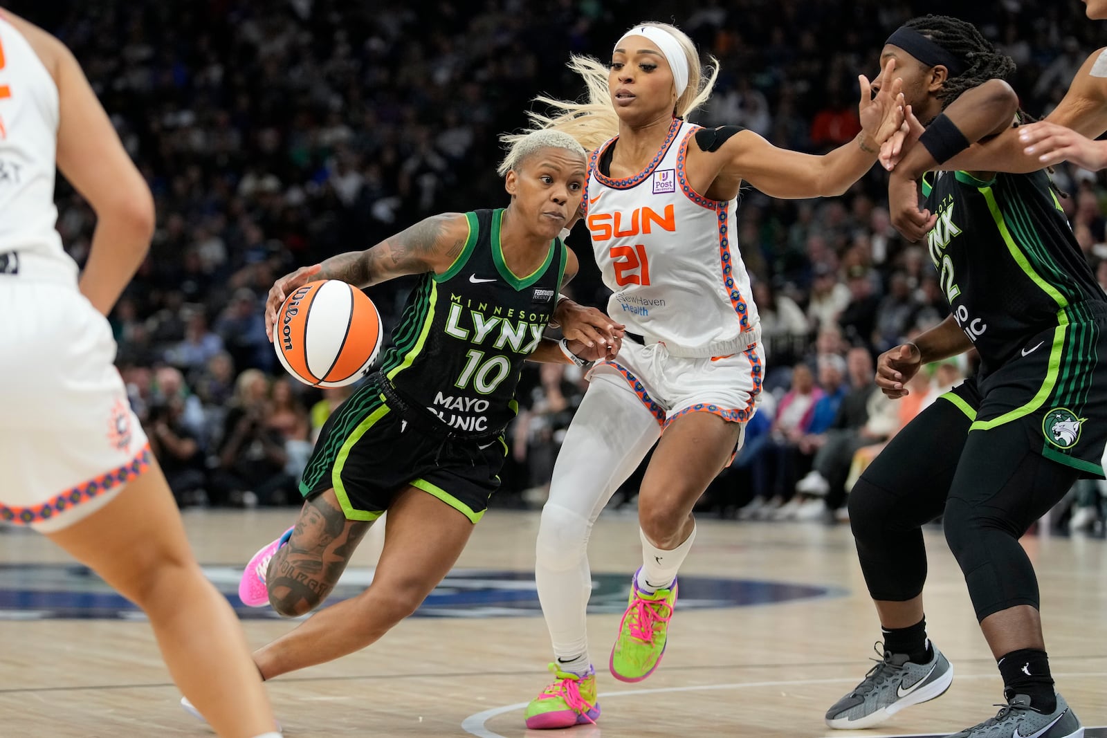 Minnesota Lynx guard Courtney Williams (10) works toward the basket as Connecticut Sun guard DiJonai Carrington (21) defends during the second half of Game 5 of a WNBA basketball semifinals, Tuesday, Oct. 8, 2024, in Minneapolis. (AP Photo/Abbie Parr)