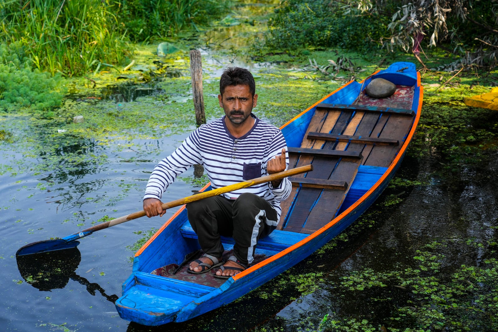 Showket Ahmad shows the indelible ink mark on his index finger on his boat after casting his vote during the second phase of the assembly election in the interior of Dal Lake in Srinagar, Indian controlled Kashmir, Wednesday, Sept. 25, 2024.(AP Photo/Mukhtar Khan)