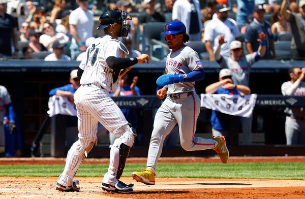 New York Mets' Francisco Lindor (12) scores a run against the New York Yankees during the fourth inning of a baseball game, Saturday, May 17, 2025, in New York. (AP Photo/Noah K. Murray)