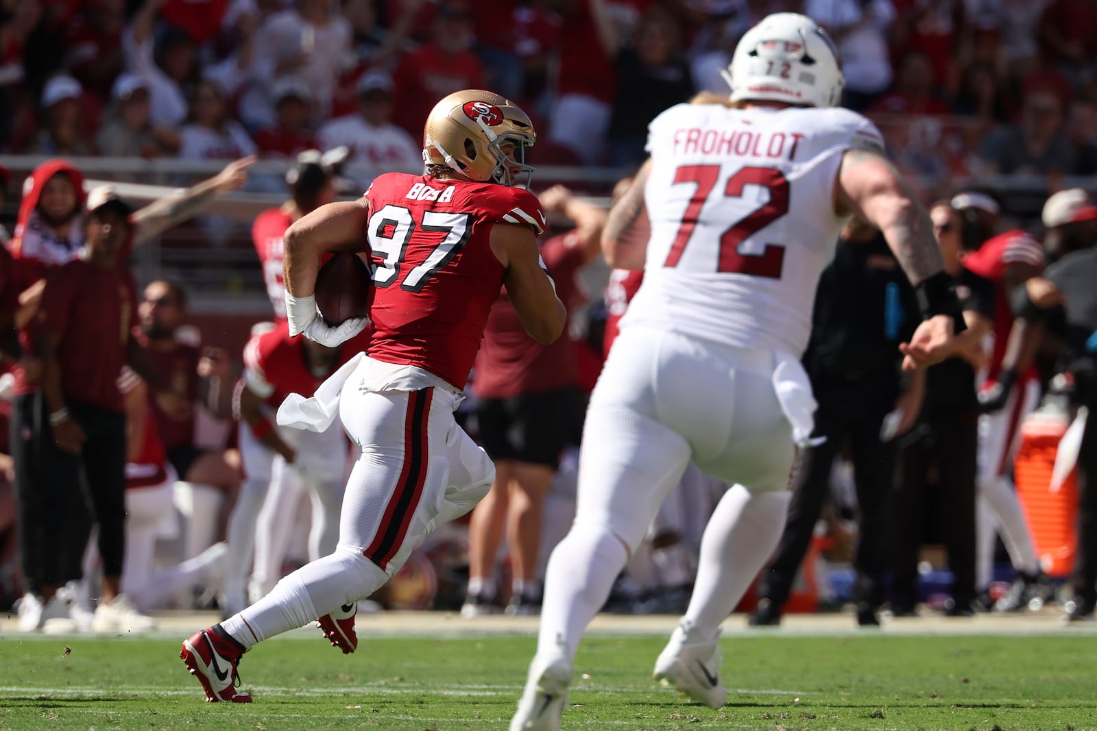 San Francisco 49ers defensive end Nick Bosa (97) returns an interception in front of Arizona Cardinals guard Hjalte Froholdt (72) during the first half of an NFL football game in Santa Clara, Calif., Sunday, Oct. 6, 2024. (AP Photo/Jed Jacobsohn)