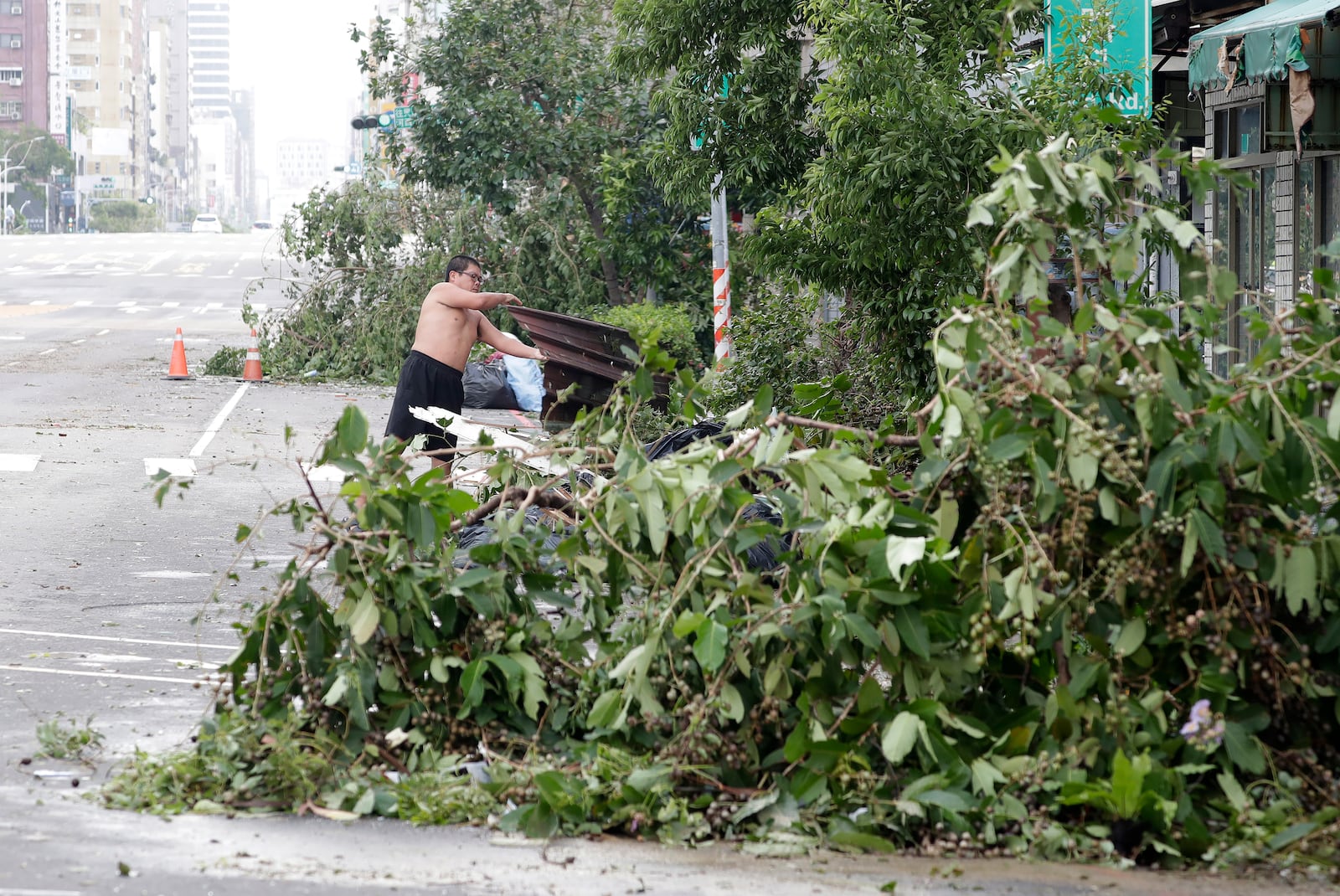 A man clears debris in the aftermath of Typhoon Krathon in Kaohsiung, southern Taiwan, Friday, Oct. 4, 2024. (AP Photo/Chiang Ying-ying)