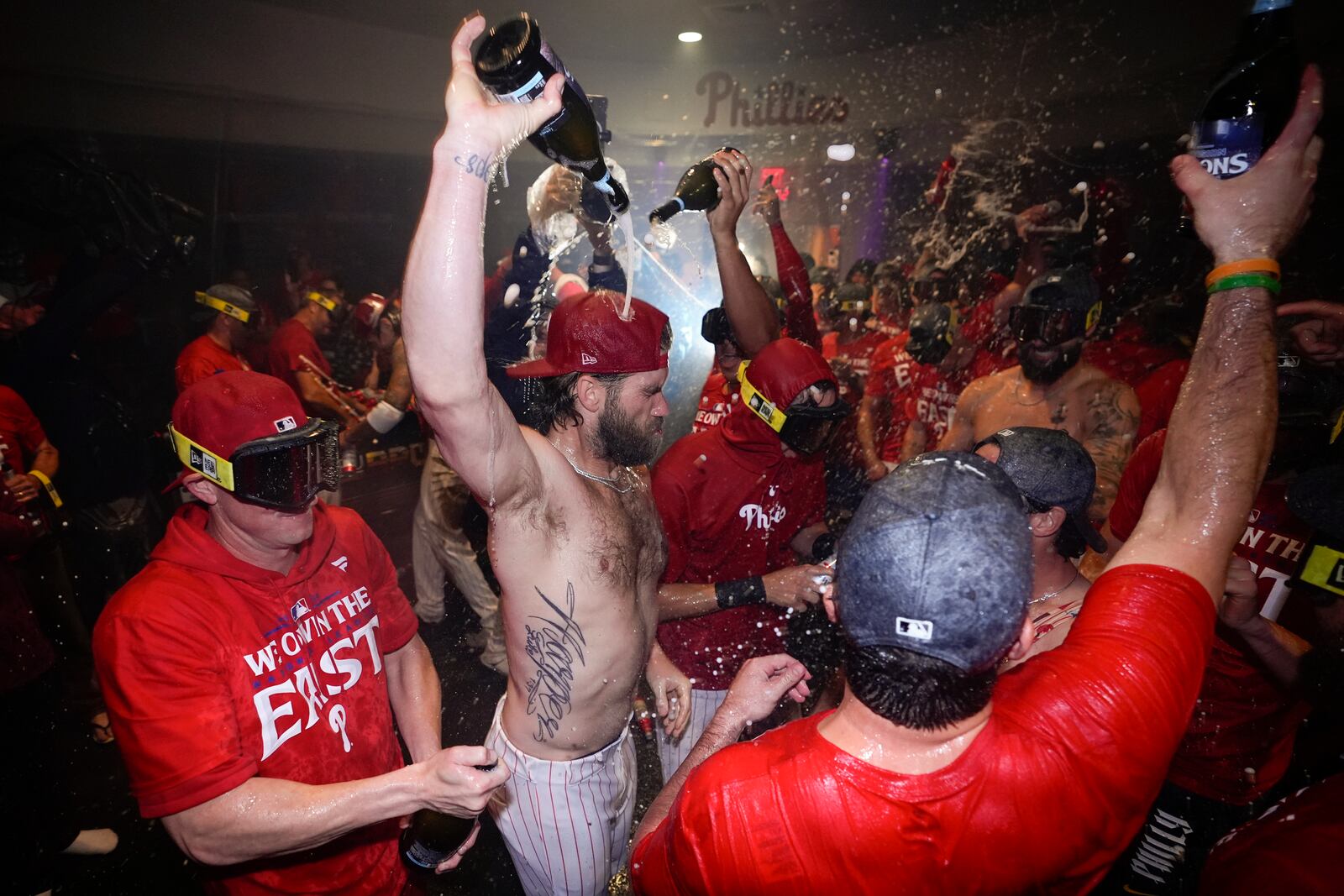 Philadelphia Phillies' Bryce Harper celebrates with teammates after the Phillies won a baseball game against the Chicago Cubs to clinch the NL East title, Monday, Sept. 23, 2024, in Philadelphia. (AP Photo/Matt Slocum)