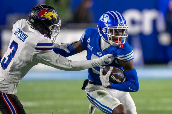 Kansas cornerback Mello Dotson (3) tackles BYU wide receiver Darius Lassiter (5) during the first half of an NCAA college football game Saturday, Nov. 16, 2024, in Provo. (AP Photo/Rick Egan)