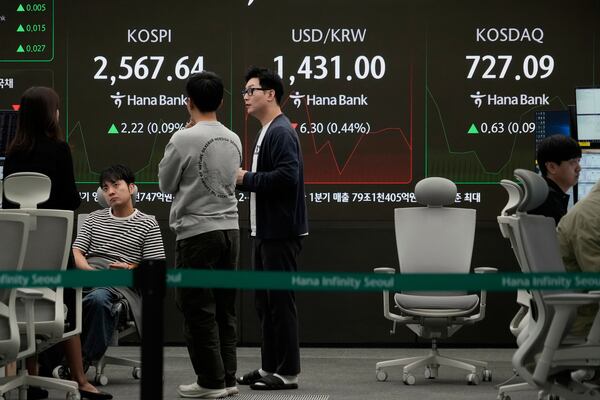 Currency traders work near a screen showing the Korea Composite Stock Price Index (KOSPI), top left, and the foreign exchange rate between U.S. dollar and South Korean won, top center, at the foreign exchange dealing room of the KEB Hana Bank headquarters in Seoul, South Korea, Wednesday, April 30, 2025. (AP Photo/Ahn Young-joon)