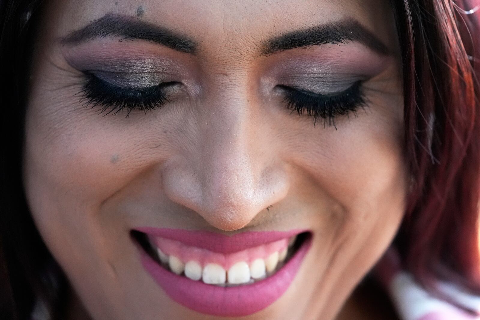 Julieth Luna Garcia, a transgender woman from El Salvador, smiles as she listens to Drew Heckman from Rainbow Railroad at Horner Park in Chicago, Monday, Sept. 30, 2024. (AP Photo/Nam Y. Huh)