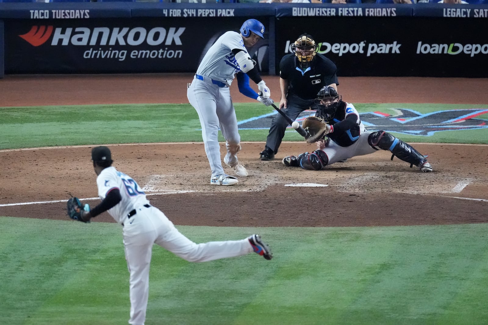 Los Angeles Dodgers' Shohei Ohtani hits a home run scoring Andy Pages off of Miami Marlins pitcher George Soriano (62) during the sixth inning of a baseball game, Thursday, Sept. 19, 2024, in Miami. (AP Photo/Wilfredo Lee)