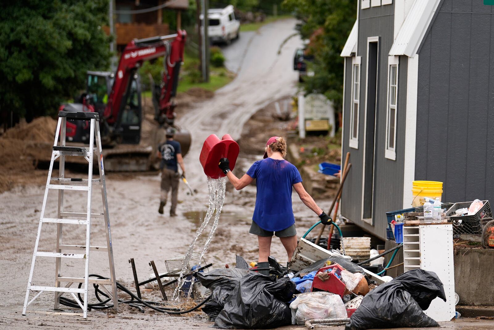 FILE - People clean up in the aftermath of Hurricane Helen, Oct. 1, 2024, in Hot Springs, N.C. (AP Photo/Jeff Roberson, File)