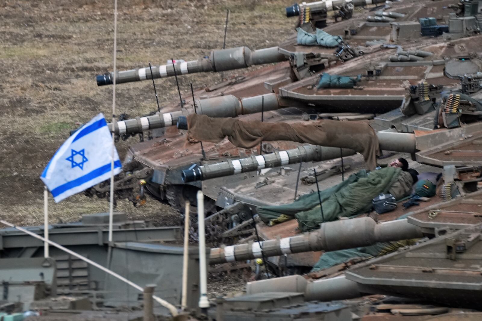 Israeli soldiers sleep on tanks in a staging area in northern Israel near the Israel-Lebanon border, Tuesday, Oct. 1, 2024. (AP Photo/Baz Ratner)