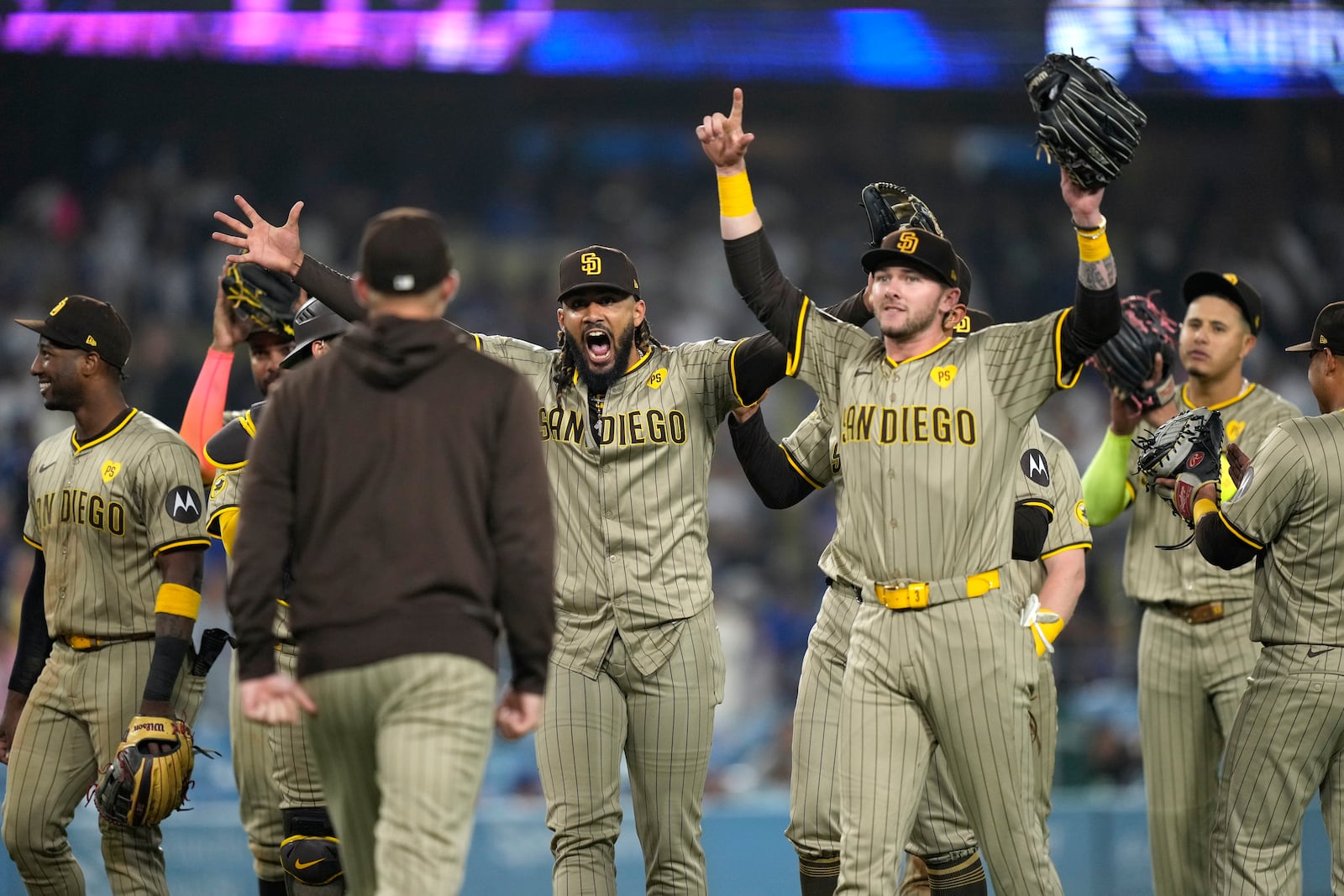 San Diego Padres' Fernando Tatis Jr., center, celebrates with teammates after the Padres clinched a playoff spot with a triple play to end their baseball game against the Los Angeles Dodgers, Tuesday, Sept. 24, 2024, in Los Angeles. (AP Photo/Mark J. Terrill)