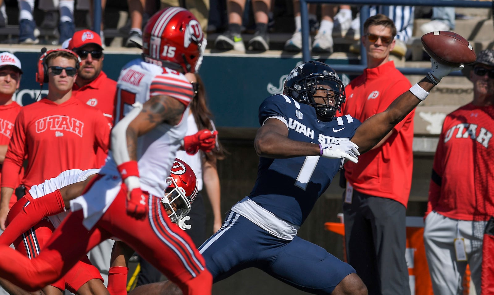 Utah State receiver Jalen Royals (1) catches a pass as Utah cornerback Zemaiah Vaughn (5), and safety Tao Johnson (15) defend in the first half of an NCAA college football game, Saturday, Sept. 14, 2024, in Logan, Utah. (Eli Lucero/Herald Journal via AP)