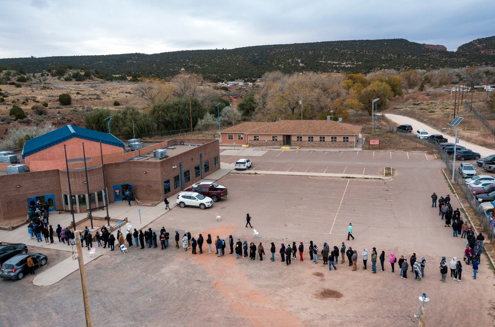 Voters wait in line to cast their ballots outside a polling station on the Navajo Nation in Fort Defiance, Ariz., on Election Day, Tuesday, Nov. 5, 2024. (AP Photo/Andres Leighton)