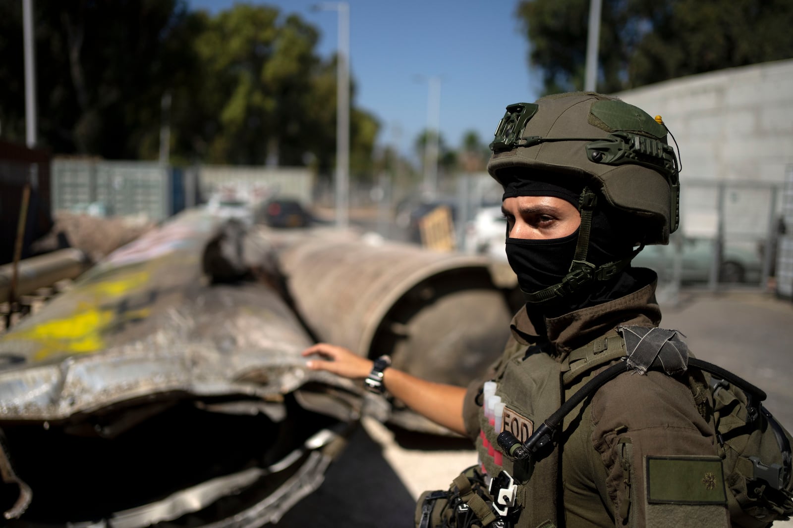 An Israeli soldier from an EOD (explosive ordnance disposal) unit gestures to Iranian ballistic missile components that were fired at Isarael, during a government-organized media tour on a base in southern Israel, Wednesday, Oct. 9, 2024. (AP Photo/Maya Alleruzzo)