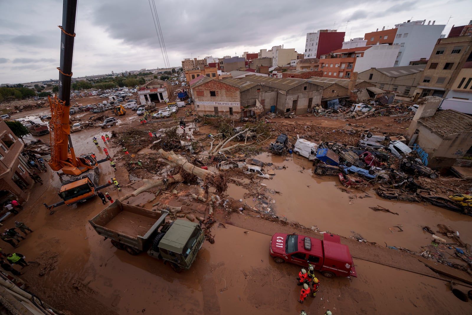 Emergency services remove cars in an area affected by floods in Catarroja, Spain, on Sunday, Nov. 3, 2024. (AP Photo/Manu Fernandez)