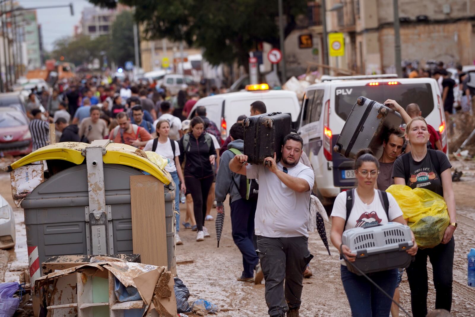 Residents carry their belongings as they leave their houses affected by floods in Valencia, Spain, Thursday, Oct. 31, 2024. (AP Photo/Alberto Saiz)