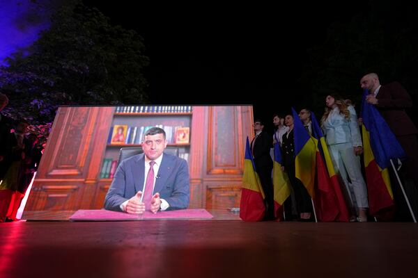 Presidential candidate George Simion is shown on a screen at the meeting of his supporters after polls closed for the first round of the country's presidential election redo in Bucharest, Romania, Sunday, May 4, 2025. (AP Photo/Andreea Alexandru)