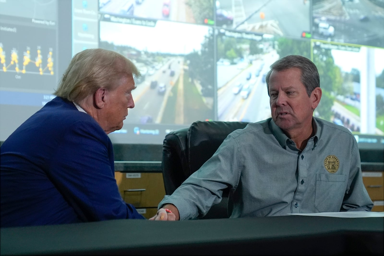 Republican presidential nominee former President Donald Trump talks with Georgia Gov. Brian Kemp during a briefing at the Columbia County Emergency Management Agency as he visits areas impacted by Hurricane Helene, Friday, Oct. 4, 2024, in Evans, Ga. (AP Photo/Evan Vucci)