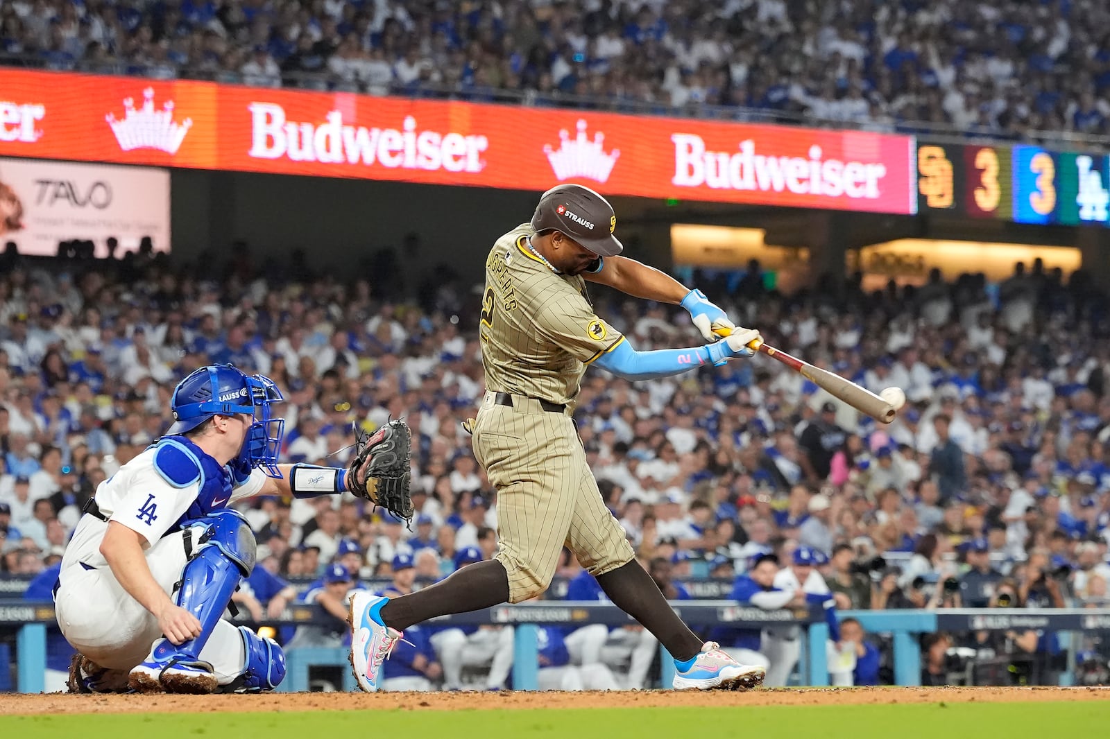 San Diego Padres' Xander Bogaerts, right, hits a two-run double in front of Los Angeles Dodgers catcher Will Smith, left, during the third inning in Game 1 of baseball's NL Division Series, Saturday, Oct. 5, 2024, in Los Angeles. (AP Photo/Mark J. Terrill)