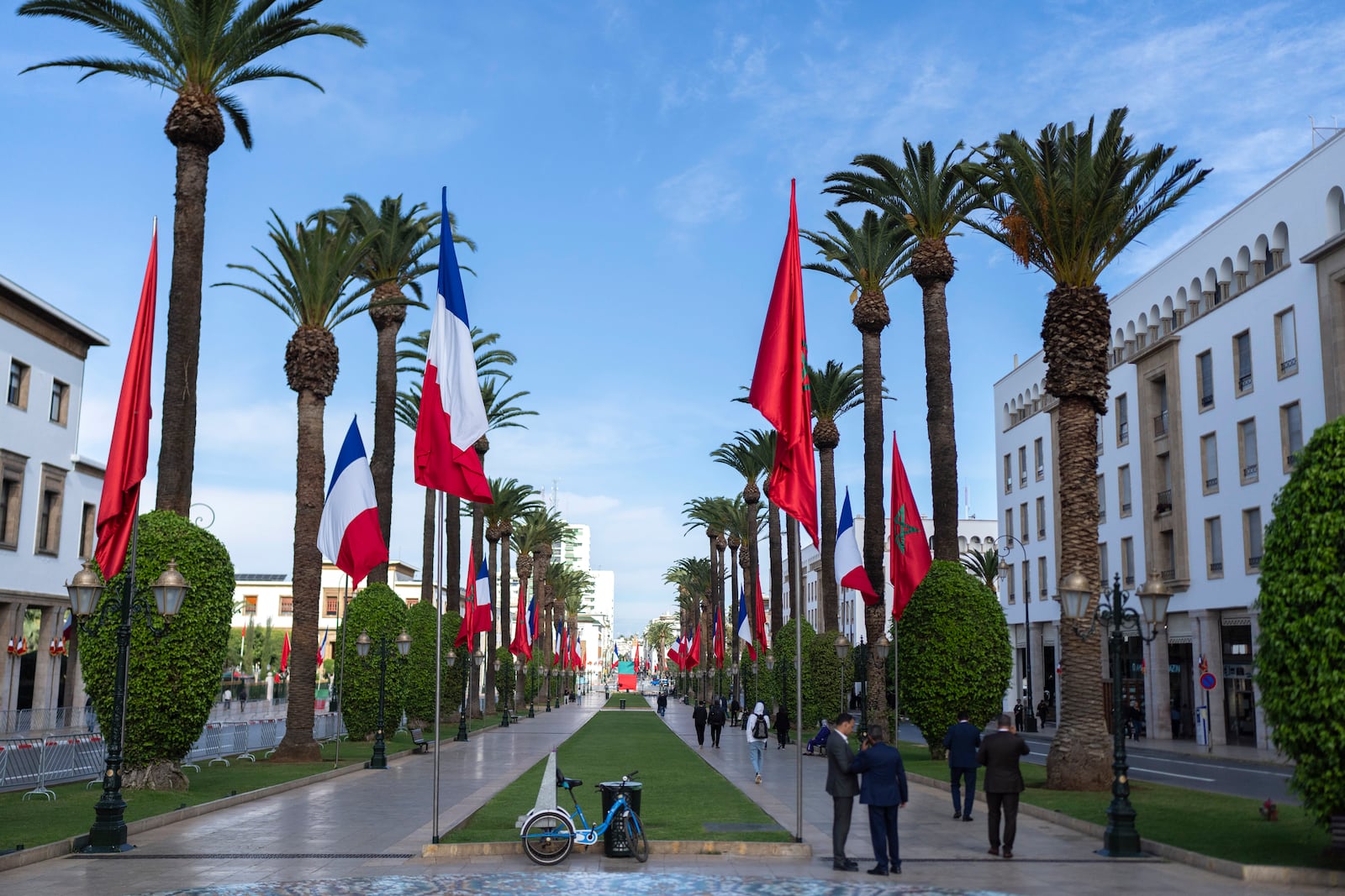 People walk past Moroccan and French flags on Mohammed V avenue ahead of French president Emmanuel Macron official visit to Morocco, in the capital Rabat, Monday, Oct. 28, 2024. (AP Photo/Mosa'ab Elshamy)