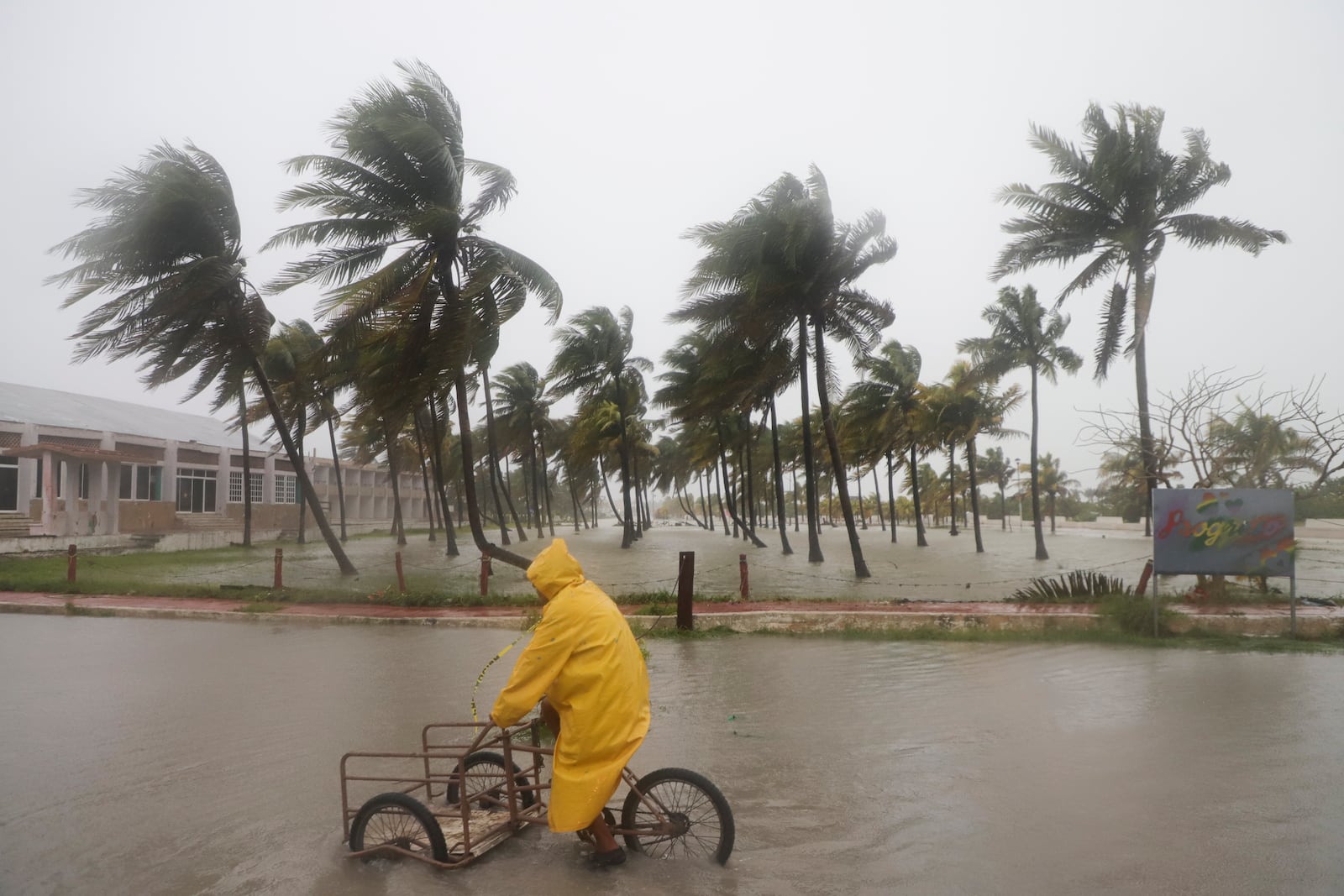 A person rides his bike through a flooded street amid rain as Hurricane Milton passes off the coast of Progreso, Yucatan state, Mexico, Tuesday, Oct. 8, 2024. (AP Photo/Martin Zetina)