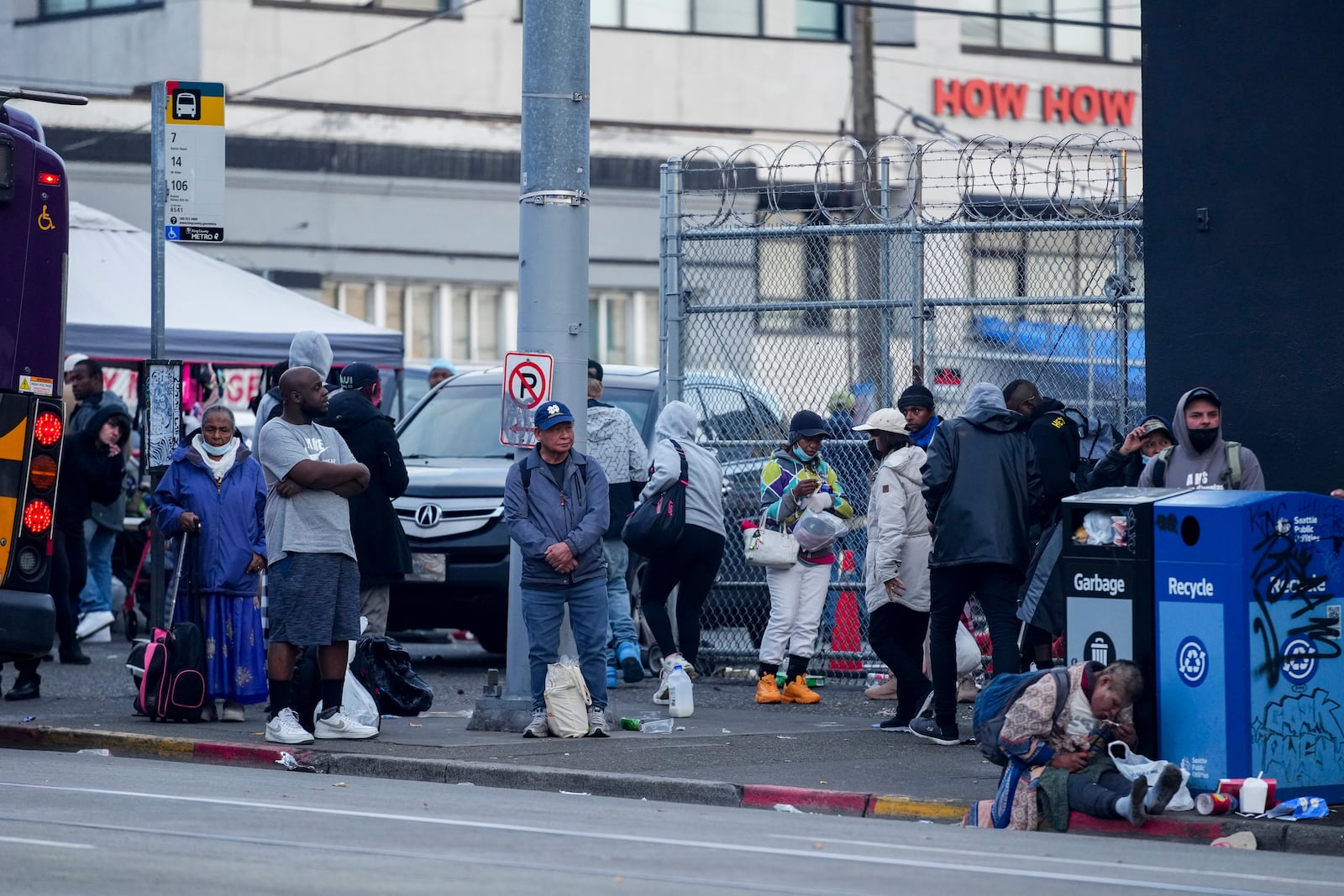 People wait for a bus near the area where multiple people were stabbed earlier Friday, Nov. 8, 2024, in the Chinatown-International District in Seattle. (AP Photo/Lindsey Wasson)