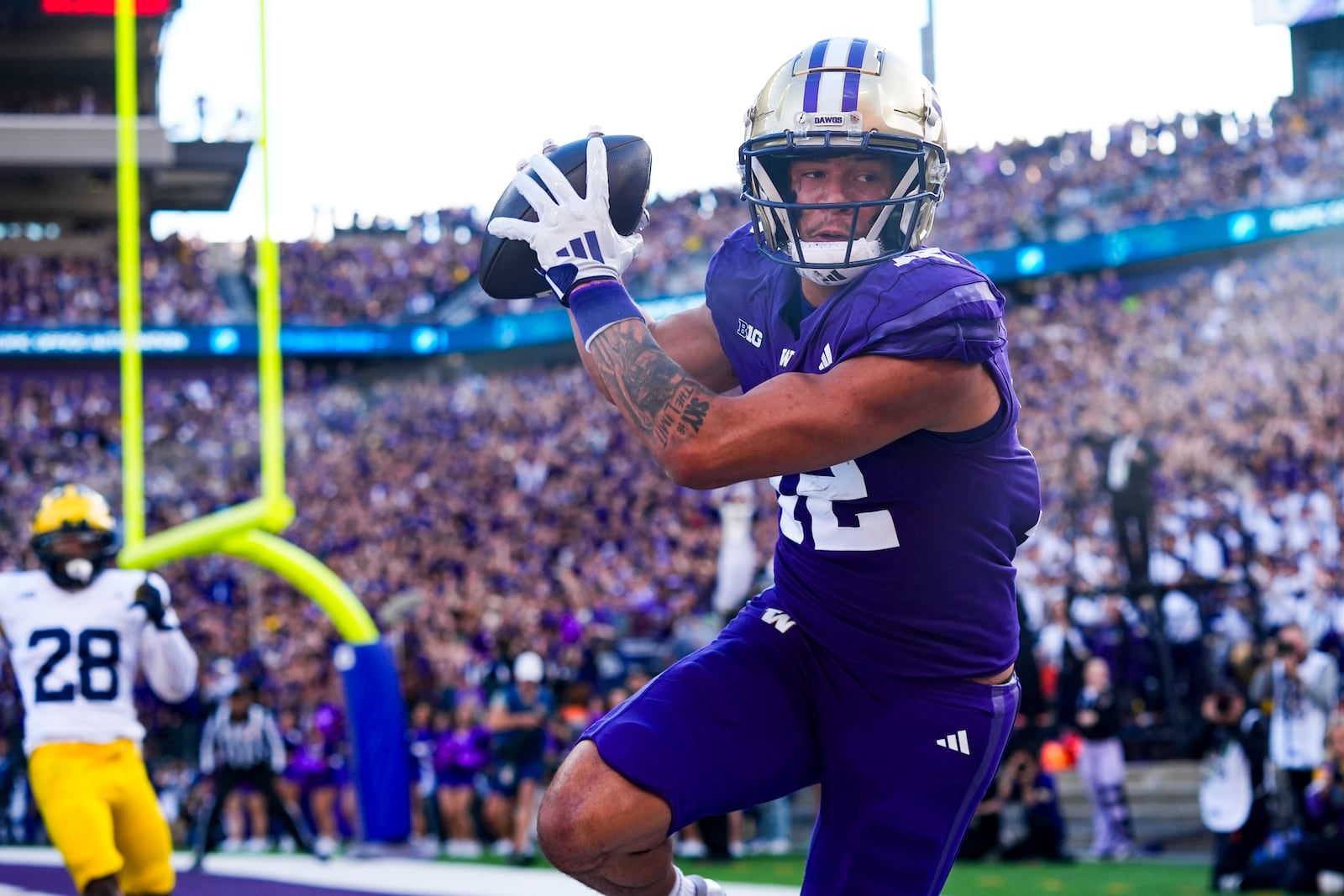 Washington wide receiver Denzel Boston makes a touchdown pass as Michigan defensive back Quinten Johnson (28) looks on during the first half of an NCAA college football game Saturday, Oct. 5, 2024, in Seattle. (AP Photo/Lindsey Wasson)