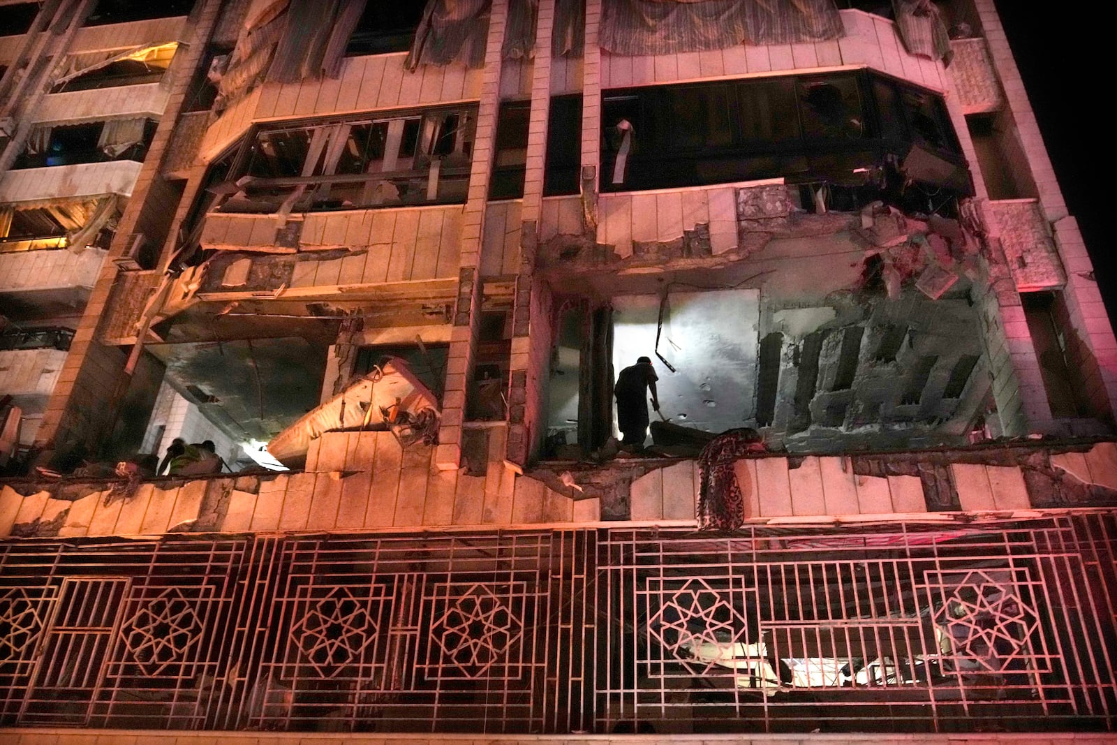 A rescue worker surveys an apartment hit by an airstrike in Beirut, Lebanon, early Thursday, Oct. 3, 2024. (AP Photo/Hussein Malla)