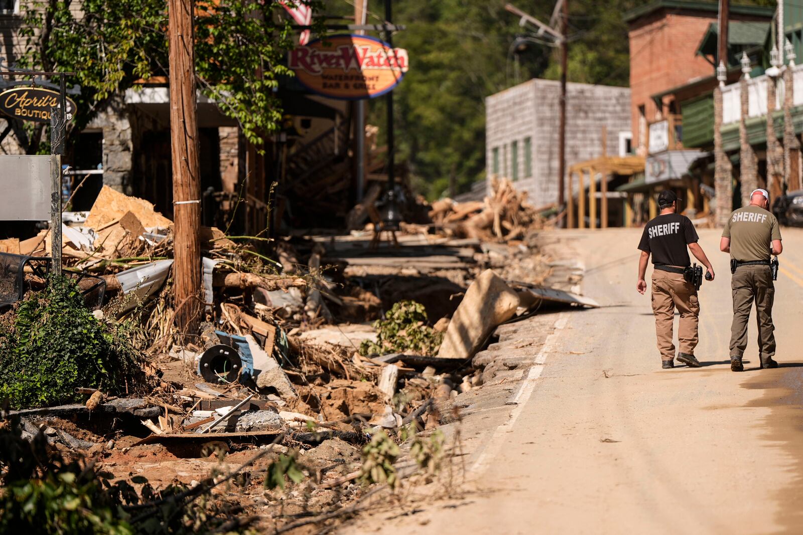 Two Sheriff deputies walk on the main street in the aftermath of Hurricane Helene, Wednesday, Oct. 2, 2024, in Chimney Rock Village, N.C. (AP Photo/Mike Stewart)