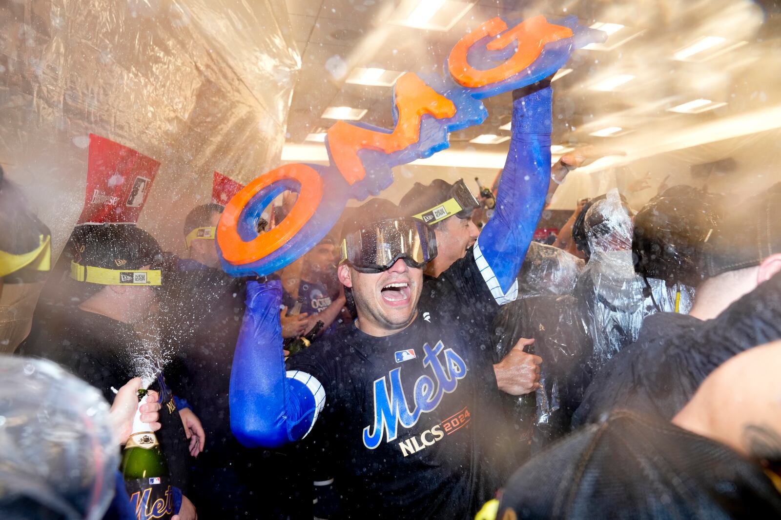 The New York Mets celebrate in the locker room after defeating the Philadelphia Phillies in Game 4 of the National League baseball playoff series, Wednesday, Oct. 9, 2024, in New York. (AP Photo/Frank Franklin II)