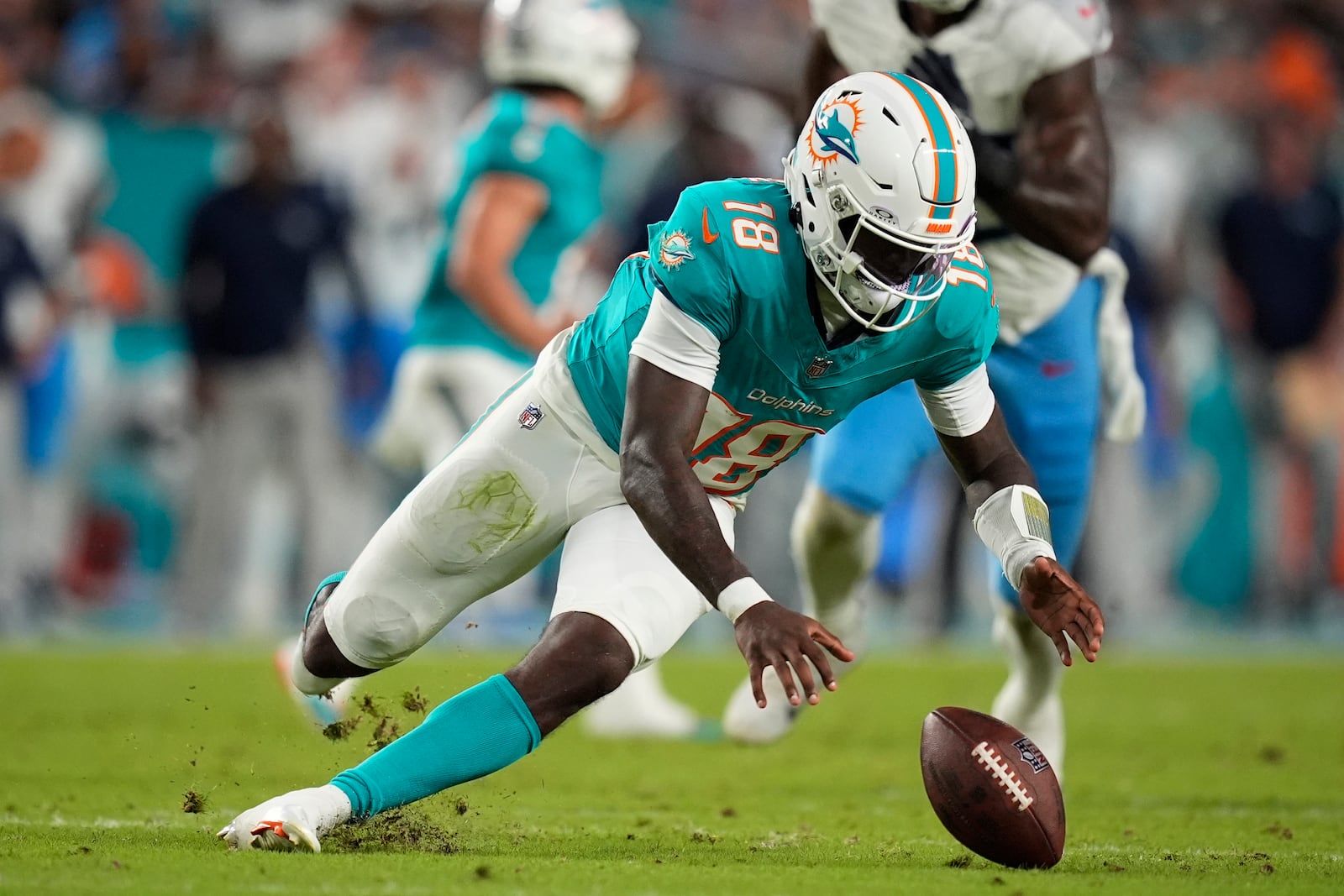 Miami Dolphins quarterback Tyler Huntley (18) goes after the ball after a bad snap during the first half of an NFL football game against the Tennessee Titans, Monday, Sept. 30, 2024, in Miami Gardens, Fla. (AP Photo/Rebecca Blackwell)