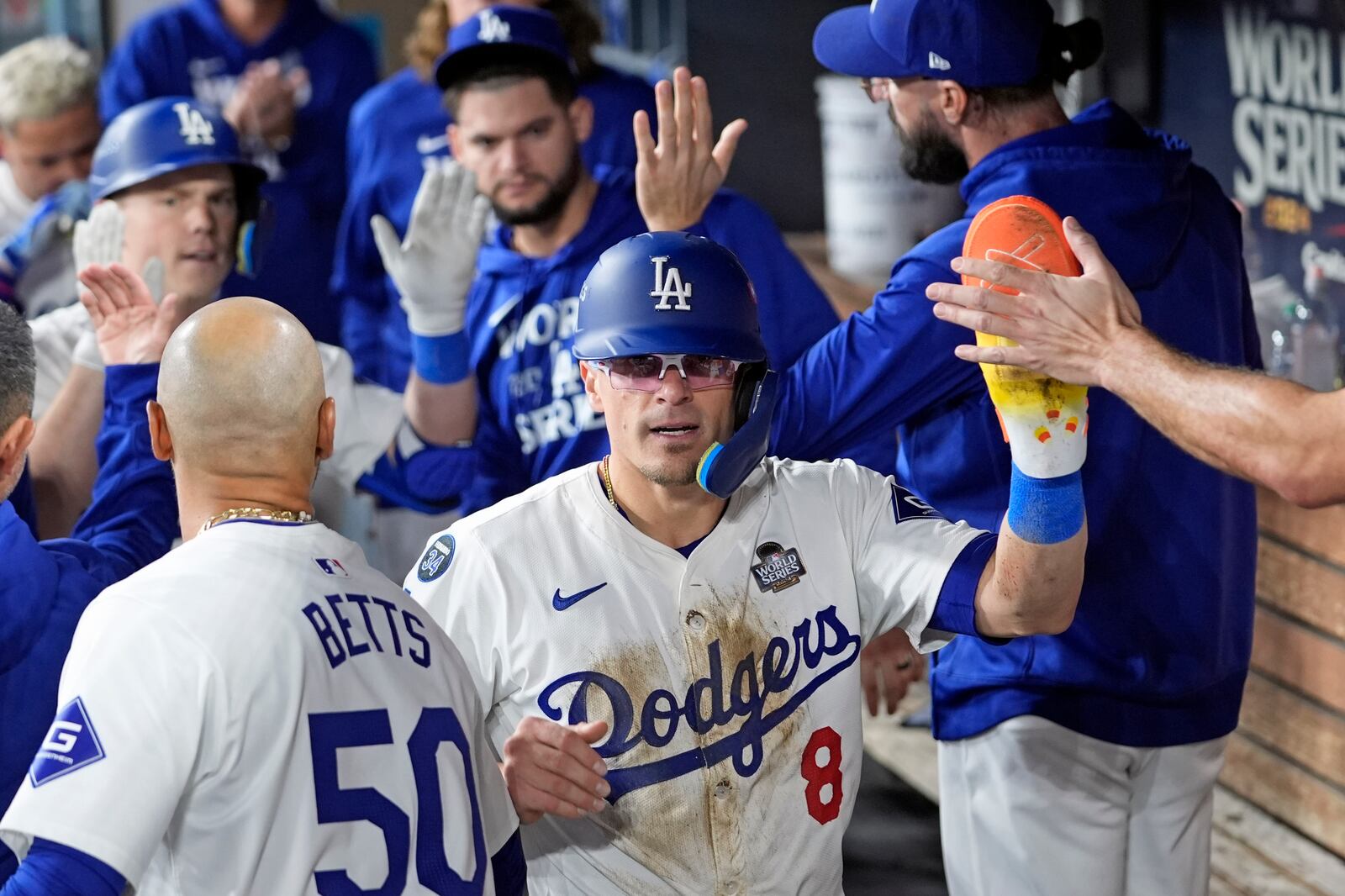 Los Angeles Dodgers' Kikí Hernández (8) celebrates in the dugout after scoring against the New York Yankees during the fifth inning in Game 1 of the baseball World Series, Friday, Oct. 25, 2024, in Los Angeles. (AP Photo/Godofredo A. Vásquez)