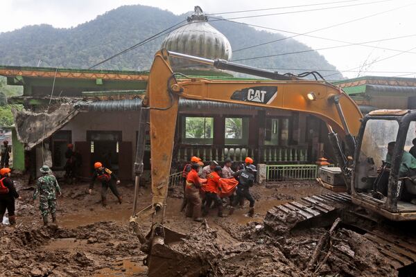 Rescuers carry the body of a victim of the landslide in Karo, North Sumatra, Indonesia, Monday, Nov. 25, 2024. (AP Photo/Binsar Bakkara)