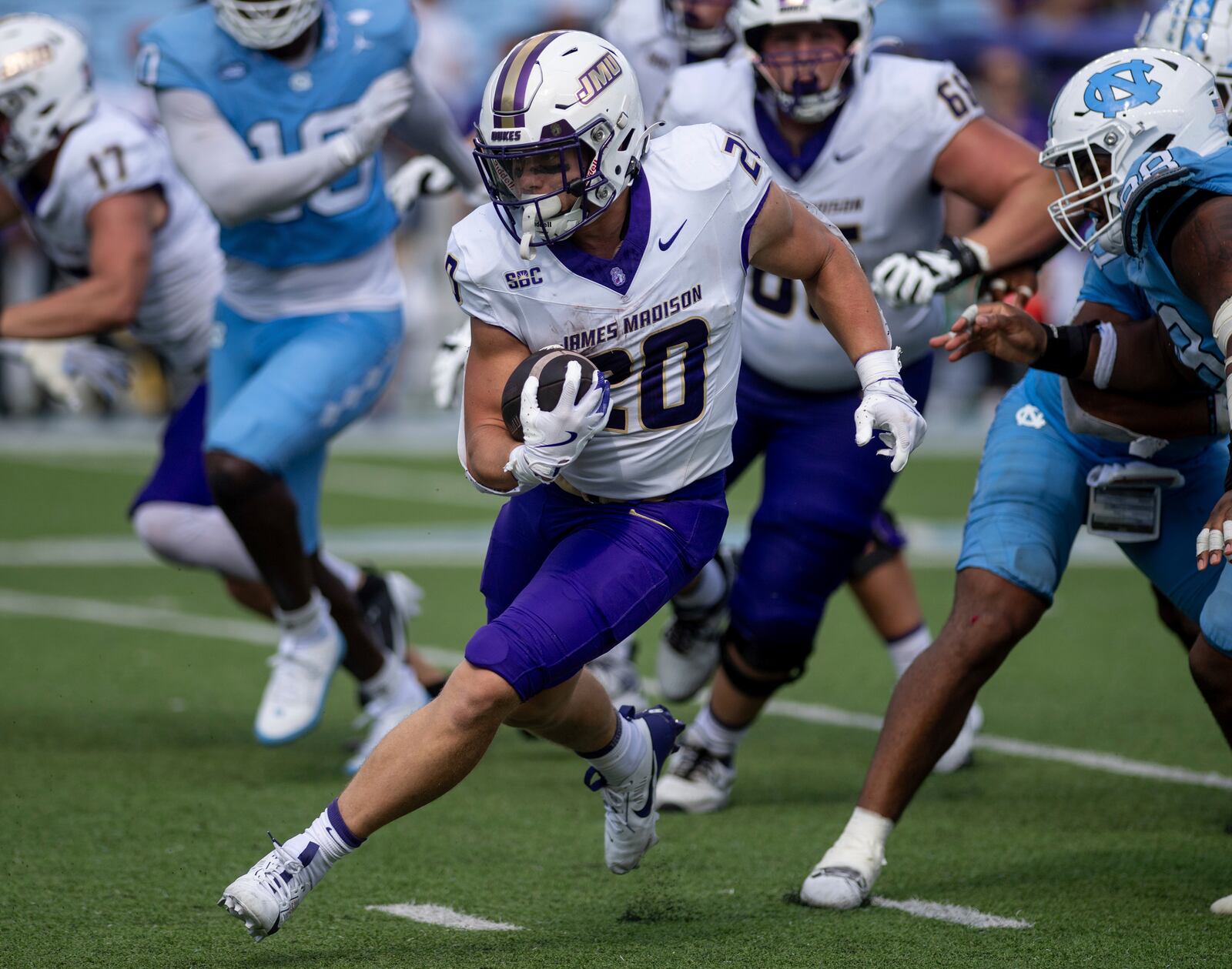 James Madison running back Tyler Purdy (20) finds a route through traffic during the second half of an NCAA college football game against North Carolina in Chapel Hill, N.C., Saturday, Sept. 21, 2024. (Daniel Lin/Daily News-Record via AP)