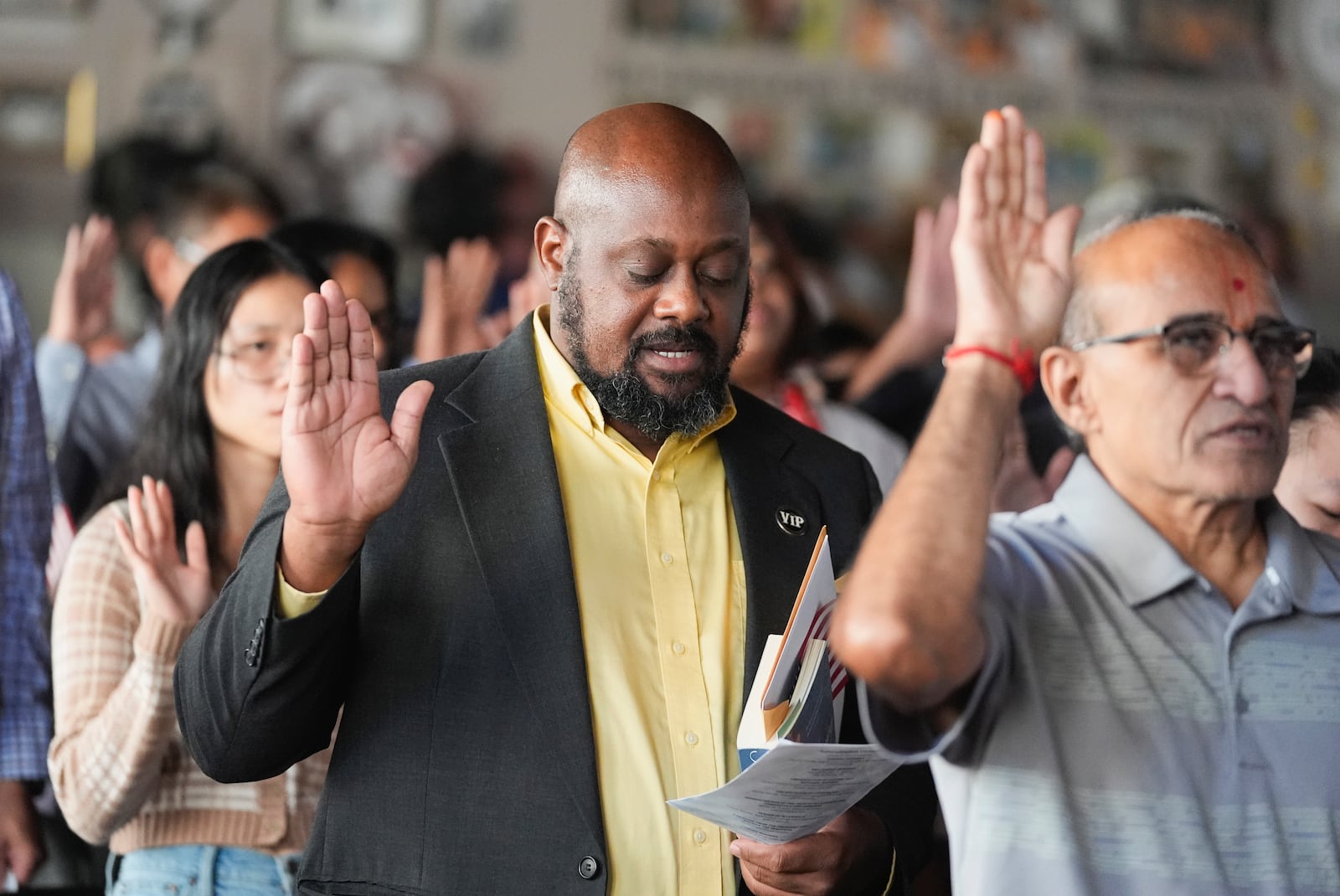 A man from Haiti takes the oath to become an American citizens during a naturalization ceremony at the high school attended by former President Jimmy Carter on Carter's 100th birthday Tuesday, Oct. 1, 2024, in Plains, Ga. (AP Photo/John Bazemore)