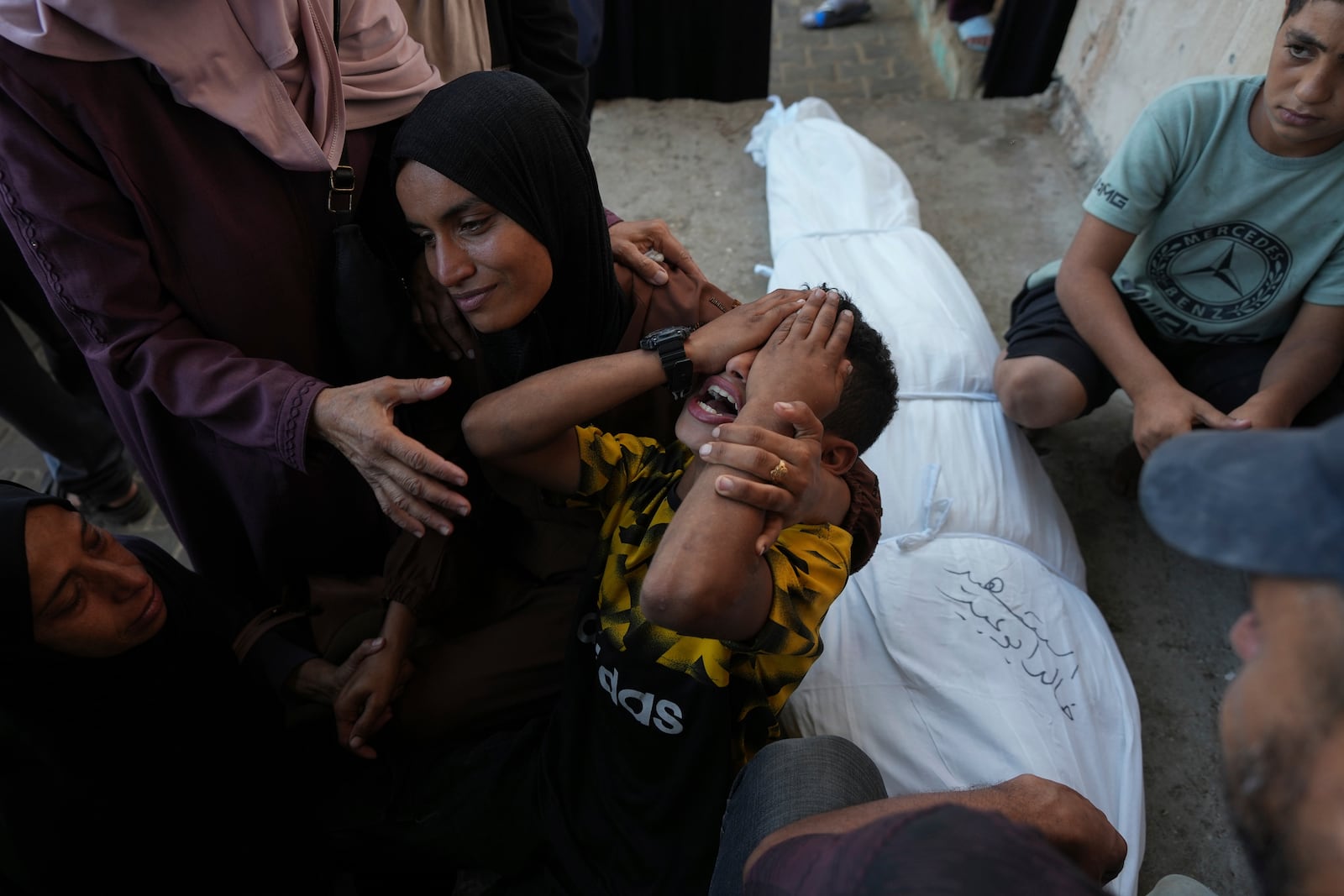 Mourners attend the funeral of Palestinians killed in the Israeli bombardment of the Gaza Strip outside the hospital morgue in Deir al-Balah on Wednesday, Oct. 9, 2024. (AP Photo/Abdel Kareem Hana)