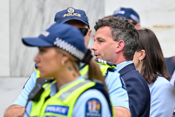 ACT Party leader David Seymour, center, looks on as thousands of people gather outside New Zealand's parliament to protest a proposed law that would redefine the country's founding agreement between Indigenous Māori and the British Crown, in Wellington Tuesday, Nov. 19, 2024. (AP Photo/Mark Tantrum)