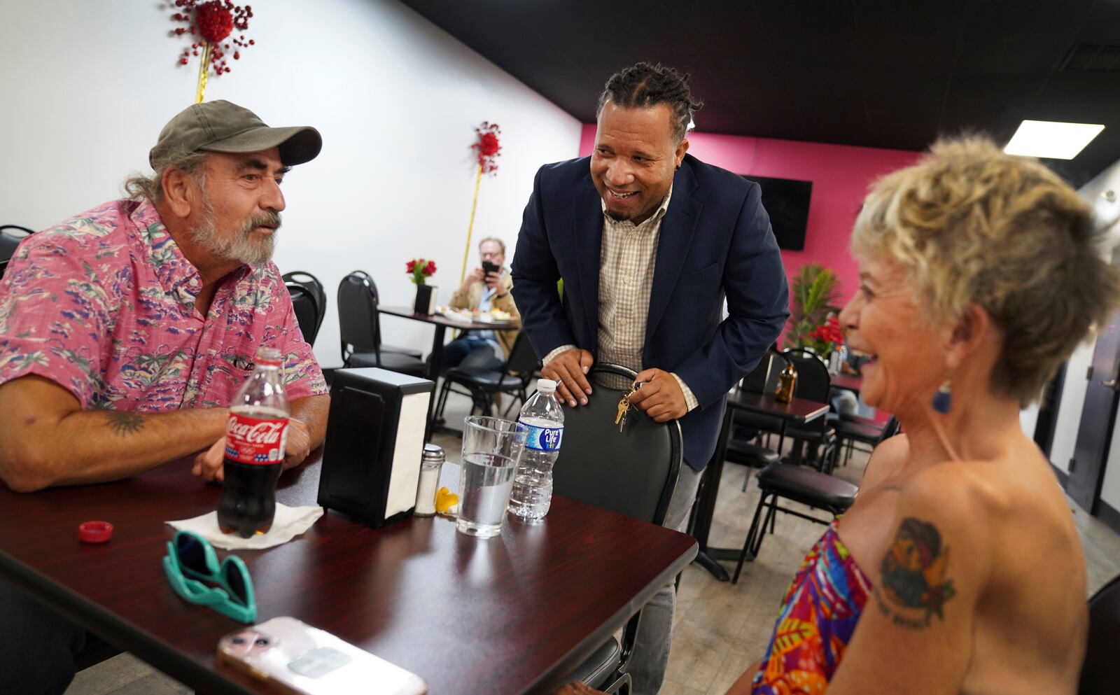 Karl Mattila, left, and his wife Linda, of Medway, Ohio, talk with Haitian and longtime Springfield resident Jacob Payen at Rose Goute Creole Restaurant in Springfield, Ohio, Monday, Sept. 16, 2024. (AP Photo/Jessie Wardarski)