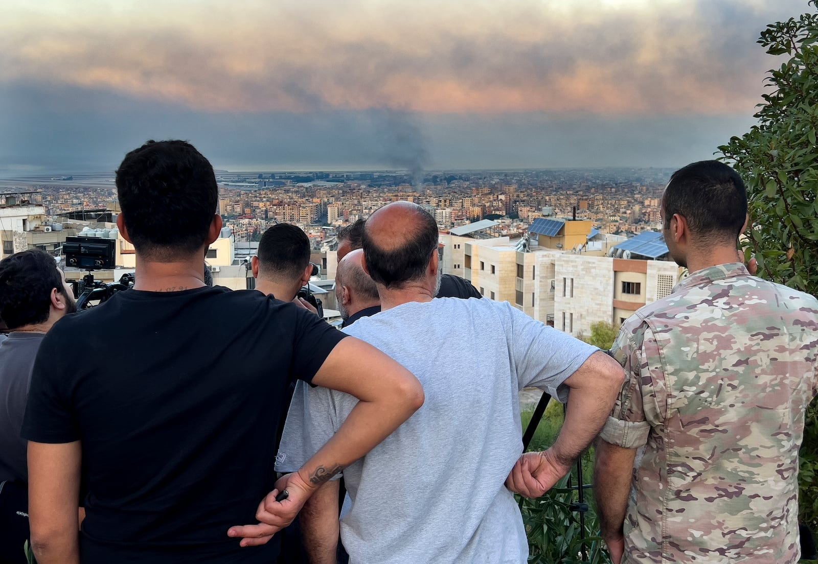 Lebanese citizens watch smoke rise from Israeli airstrikes in the southern suburbs of Beirut, Lebanon, Saturday, Sept. 28, 2024. (AP Photo/Hussein Malla)