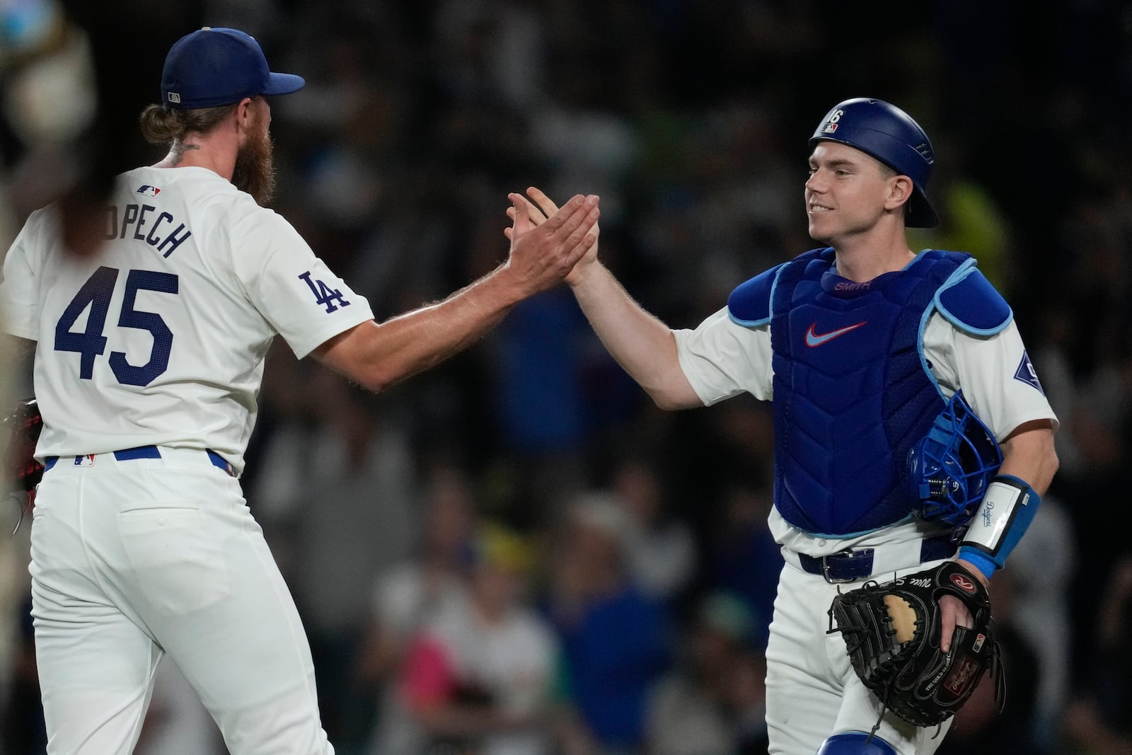 Los Angeles Dodgers relief pitcher Michael Kopech, left, celebrates with teammate catcher Will Smith after the Dodgers defeated the San Diego Padres 7-2 in a baseball game to clinch the National League West division Thursday, Sept. 26, 2024, in Los Angeles. (AP Photo/Ashley Landis)