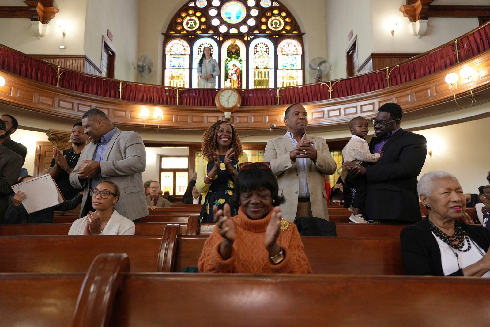 Mother Bethel AME Church member Donna Matthews, center standing, claps next to her husband, Keith Matthews, during a service in Philadelphia on Sunday, Oct. 13, 2024. (AP Photo/Luis Andres Henao)