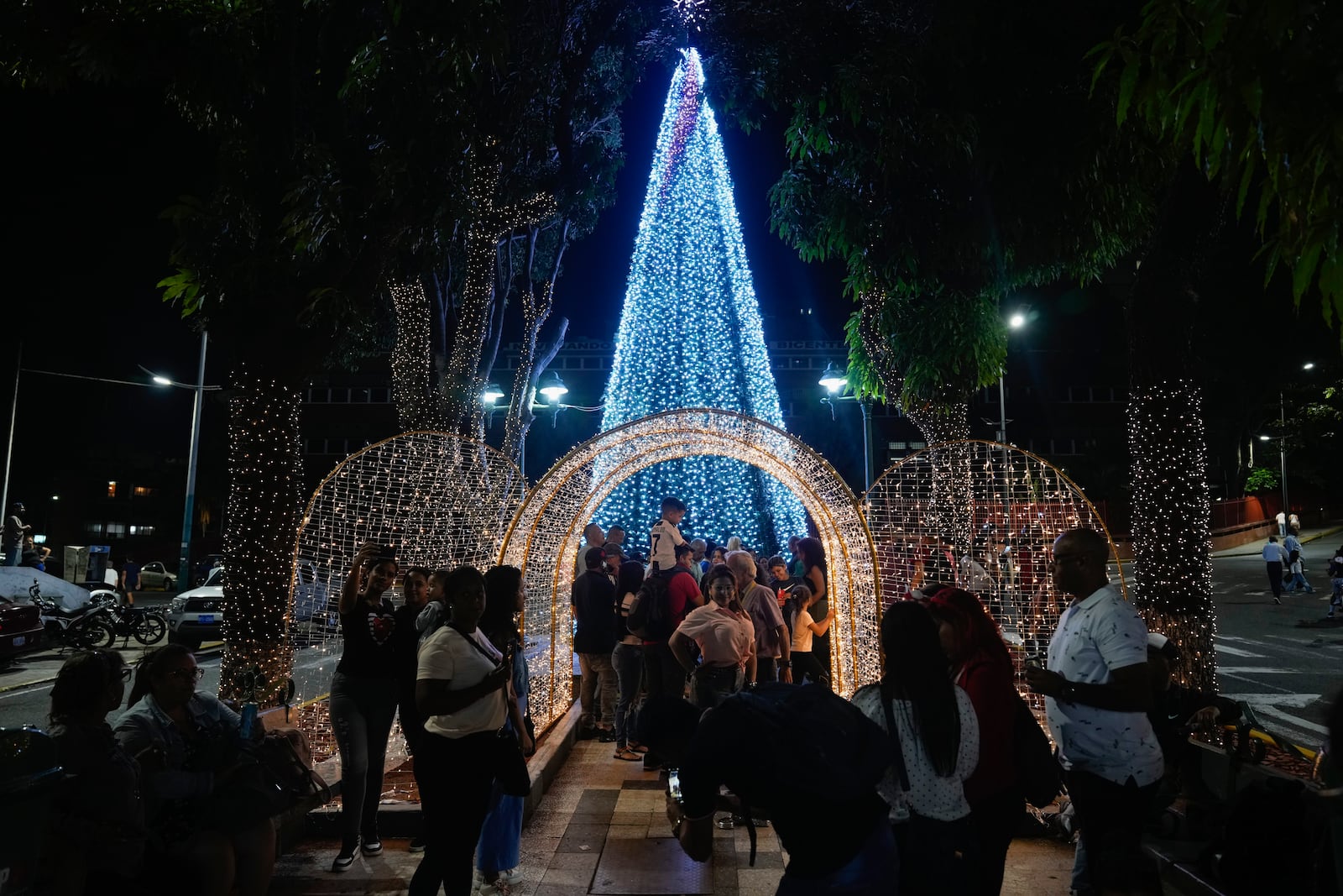 People take photos in front of Christmas decorations in Caracas, Venezuela, Tuesday, October. 1, 2024. (AP Photo/Ariana Cubillos)