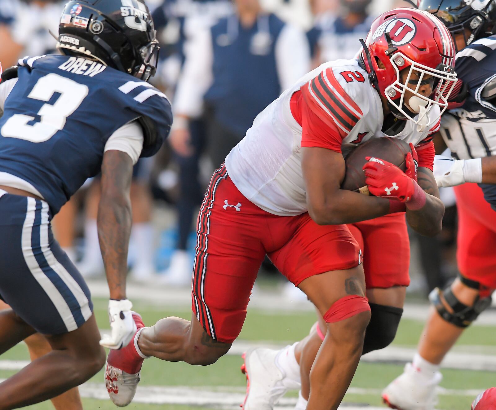 Utah running back Micah Bernard (2) carries the ball as Utah State cornerback JD Drew (3) pursues in the second half of an NCAA college football game Saturday, Sept. 14, 2024, in Logan, Utah. (Eli Lucero/The Herald Journal via AP)